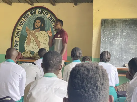 Speaker leading a prayer session with secondary school students, The Gambia, 2022
