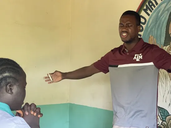 Speaker leading a prayer session with secondary school students, The Gambia, 2022
