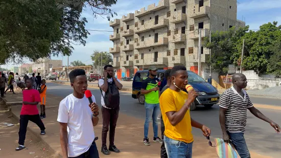 Young people marching together in a street outreach, The Gambia, 2022