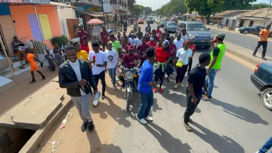 Young people marching together in a street outreach, The Gambia, 2022