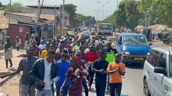 Young people marching together in a street outreach, The Gambia, 2022