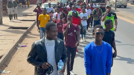 Young people marching together in a street outreach, The Gambia, 2022