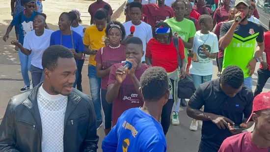 Young people marching together in a street outreach, The Gambia, 2022