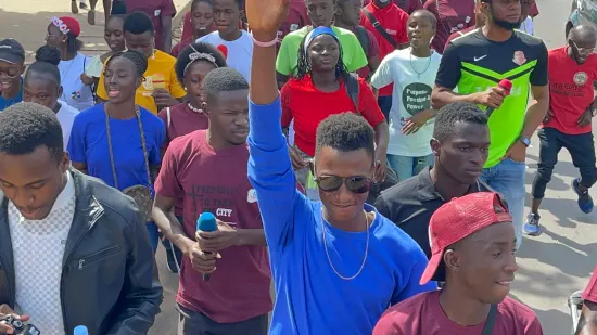 Young people marching together in a street outreach, The Gambia, 2022