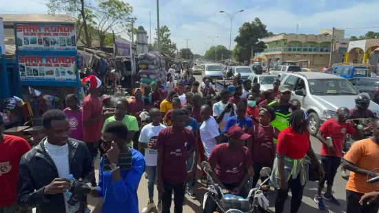 Young people marching together in a street outreach, The Gambia, 2022