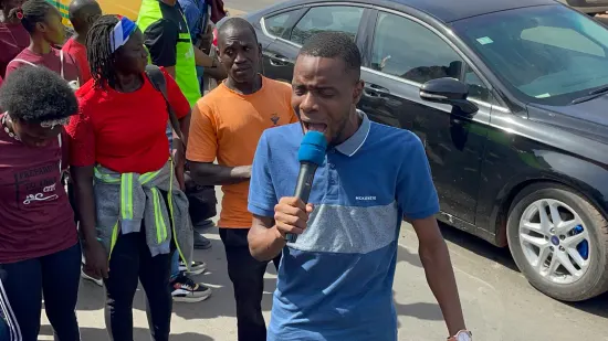 Young people marching together in a street outreach, The Gambia, 2022