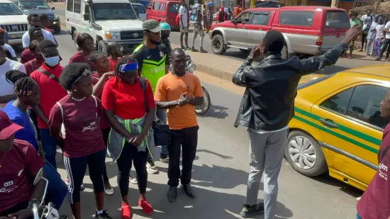 Young people marching together in a street outreach, The Gambia, 2022