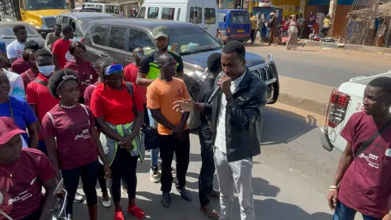 Young people marching together in a street outreach, The Gambia, 2022