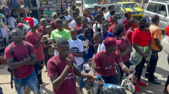 Young people marching together in a street outreach, The Gambia, 2022