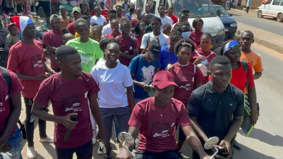 Young people marching together in a street outreach, The Gambia, 2022
