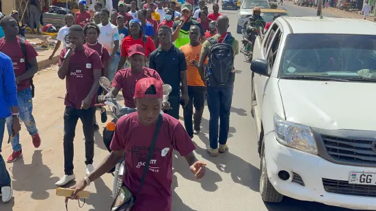 Young people marching together in a street outreach, The Gambia, 2022