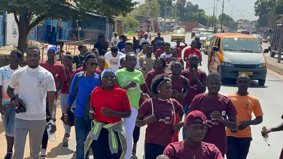 Young people marching together in a street outreach, The Gambia, 2022