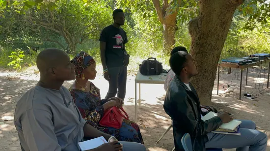 Outdoor community church service under the trees, The Gambia, 2022