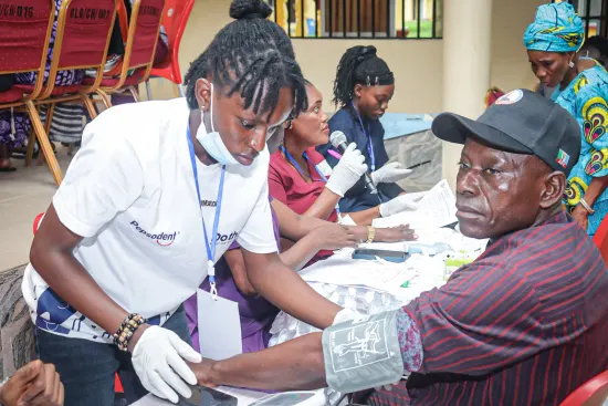 Volunteer nurse checking a patient at the clinic table